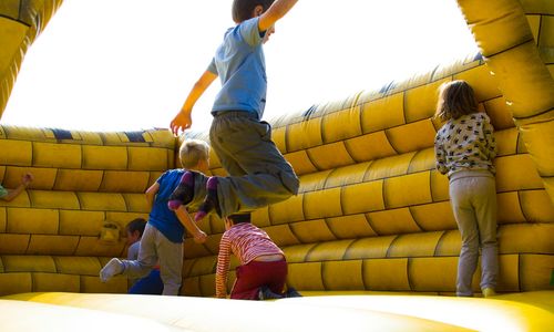 Group of energetic kids playing together in a bright room.